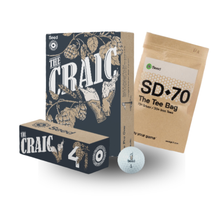 Load image into Gallery viewer, A golf tee bag kit featuring a dark navy and beige 'The Craic' box, a kraft paper 'SD-70 The Tee Bag' pouch, and a single white golf ball on a clean white background.
